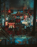 A bustling casino floor filled with groups of slot machines and people walking around. The atmosphere is vibrant with neon lights and illuminated signs. The interior has a ceiling supported by large pillars and there are stairs leading down to the gaming area.